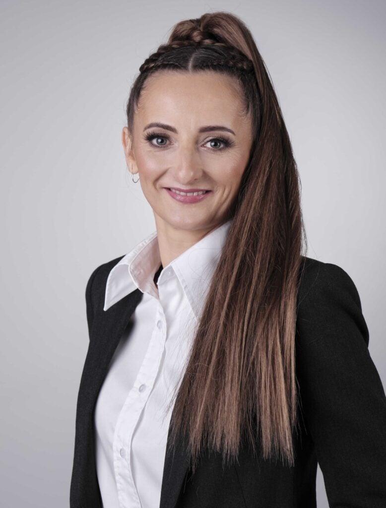 Kobieta w biznesowym stroju, długie włosy.