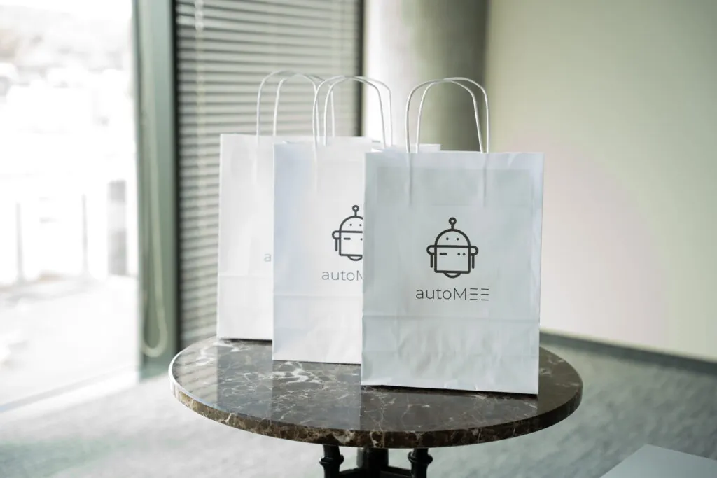 Three paper bags with robot logo on table.
